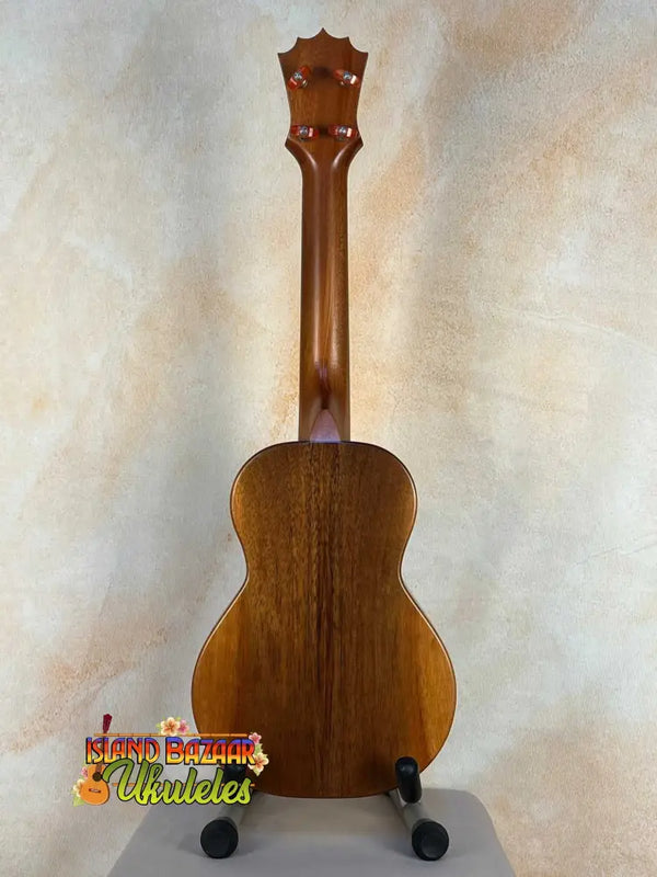 Wooden KoAloha KCM-10 Concert Ukulele in Solid Hawaiian Koa on black display stand