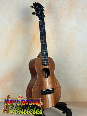 Wooden KoAloha KCM-10RP Concert Ukulele in Royal Pikake finish on a black stand