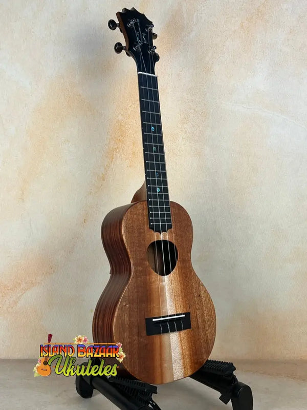 Wooden KoAloha KCM-10RP Concert Ukulele in Royal Pikake finish on a black stand