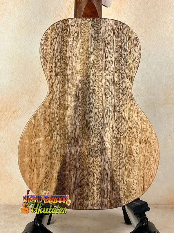 Wooden acoustic guitar showcasing solid mango wood grain patterns on stand, KoAloha KCM-10RP-MG Concert