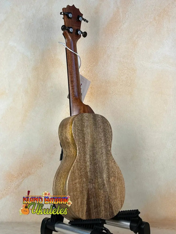 Wooden ukulele on black stand showcasing KoAloha KCM-10RP-MG Concert in solid Mango wood