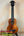 Wooden soprano ukulele with black headstock on stand, showcasing KoAloha KSM-00 design