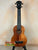 Wooden soprano ukulele with black headstock on stand, showcasing KoAloha KSM-00 design