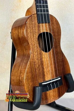 Wooden KoAloha KSM-00 Soprano Ukulele with Hawaiian Koa and ebony fretboard on black stand