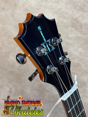 Black koaloha ktm-00 tenor ukulele headstock with glossy finish and iridescent logo for authentic hawaiian sound