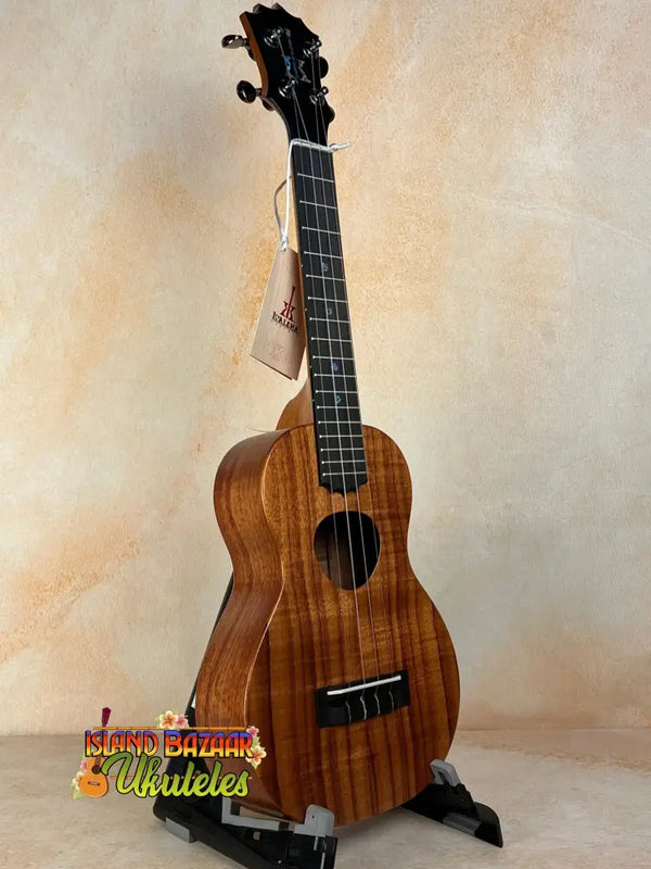 Wooden ukulele with dark grain patterns and black pegs, featuring KoAloha Royal Pikake KCM-00RP