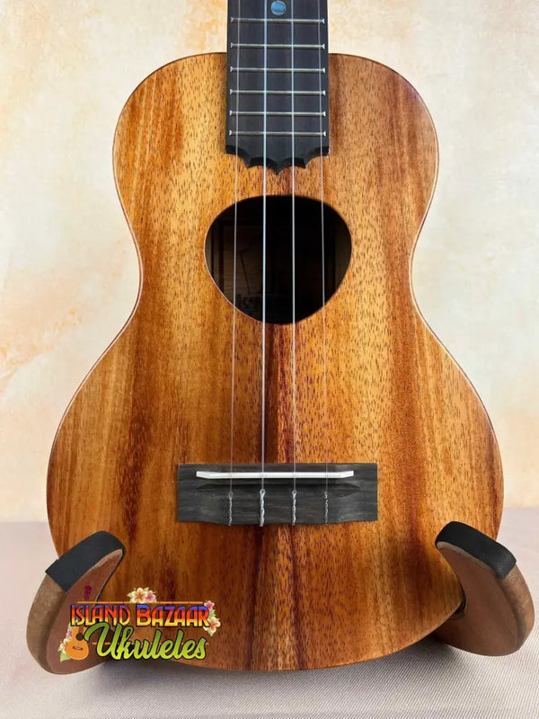 Wooden ukulele with koa finish and black fretboard, perfect for the KoAloha Royal Pikake Concert