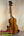 Wooden ukulele on a stand, showcasing the KoAloha Royal Pikake Concert Ukulele