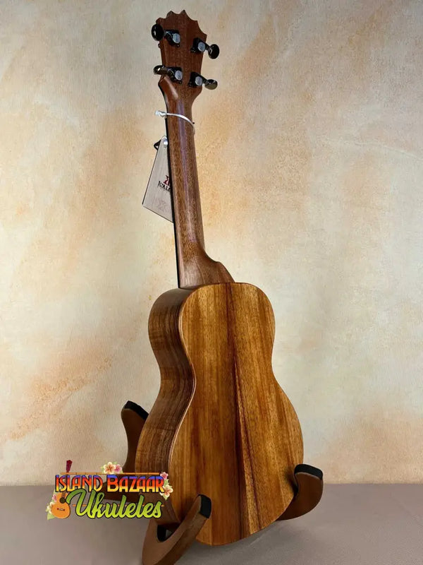 Wooden ukulele on a stand, showcasing the KoAloha Royal Pikake Concert Ukulele