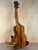 Wooden ukulele on a stand, showcasing the KoAloha Royal Pikake Concert Ukulele