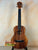 Wooden ukulele with dark fretboard and natural grain, Koaloha Royal Pikake Tenor