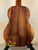 Wooden acoustic guitar with rich brown grain patterns, showcasing Koaloha Royal Pikake