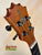 Wooden guitar headstock of Koaloha Royal Pikake Tenor Ukulele with black tuning pegs