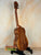 Wooden Koaloha Royal Pikake Tenor Ukulele on a black stand with satin-finish koa