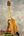 Light brown Koaloha Royal Pikake tenor ukulele with black tuning pegs on a stand