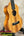 Light-colored wooden Koaloha Royal Pikake Tenor Ukulele with solid Hawaiian koa finish on stand