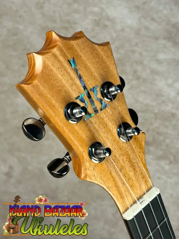 Headstock of Koaloha Royal Pikake tenor ukulele with mother-of-pearl inlay and chrome tuners