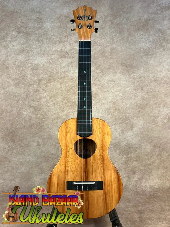 Light brown wooden Koaloha Royal Pikake tenor ukulele with black fretboard and bridge