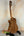 Wooden acoustic guitar on black stand showcasing Luna Vista Deer Tenor Electric Ukulele