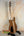 Wooden bass guitar on a black stand for Mann Electric Tenor Ukulele Solid Body