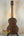 Wooden Nebula Tenor Ukulele on a black stand showcasing Western Red Cedar and Claro Walnut craftsmanship