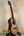 Natural wood Nebula Tenor Ukulele with dark fretboard on a stand, showcasing Claro Walnut craftsmanship