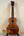 Wooden Kamaka Concert Ukulele HF-2 in Solid Koa on black stand with dark fretboard