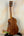 Wooden Kamaka Concert Ukulele HF-2 with tuning pegs on a stand and deluxe hard case