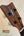 Wooden ukulele headstock with black tuning pegs and blue arrow on Kamaka HF-2 Ukulele