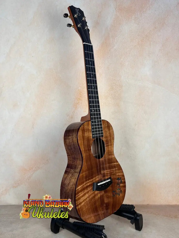 Beautiful Premium Curly Koa Kanile’a Honus Tenor Ukulele on a black stand