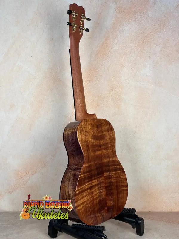 Wooden acoustic guitar showcasing rich brown Koa grain in Kanile’a Honus Tenor Ukulele