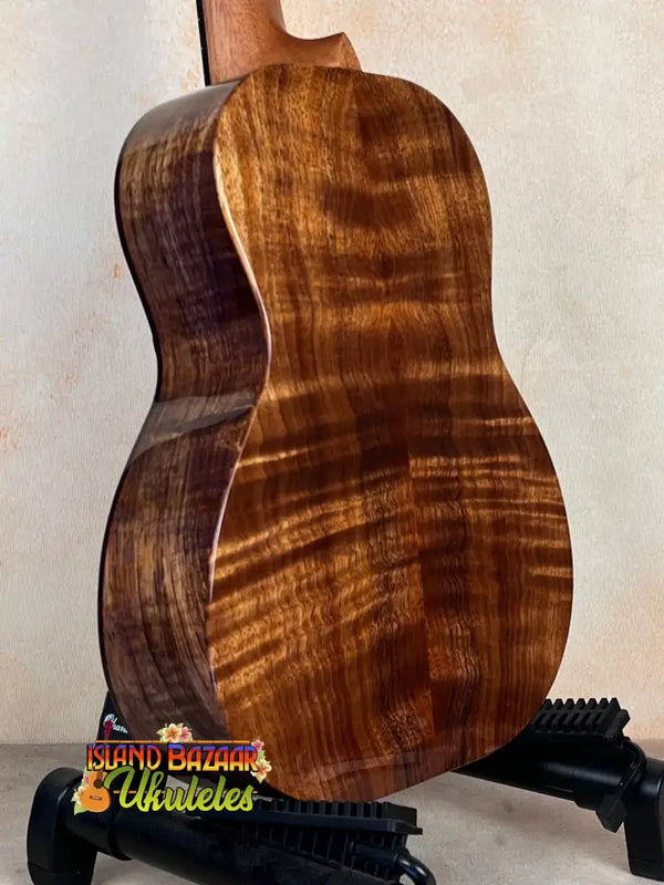 Acoustic guitar back of Kanile’a Honus Tenor Ukulele in premium curly koa wood