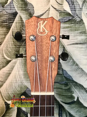 Wooden ukulele headstock with KC logo and tuning pegs from Kanile’a K-1 Soprano in Premium Hawaiian Koa