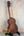 Wooden Kamaka HF-3I Slothead Tenor Ukulele on a black stand for display