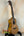 Natural wood tenor ukulele on a black stand showcasing Ohana CK-50WG Concert design