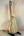 Wooden acoustic guitar on a black stand next to Ohana CK-75CG Concert Ukulele