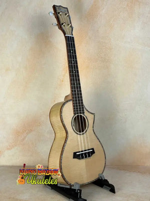 Light-colored wooden Ohana CK-75CG Concert Ukulele on a black stand, limited edition