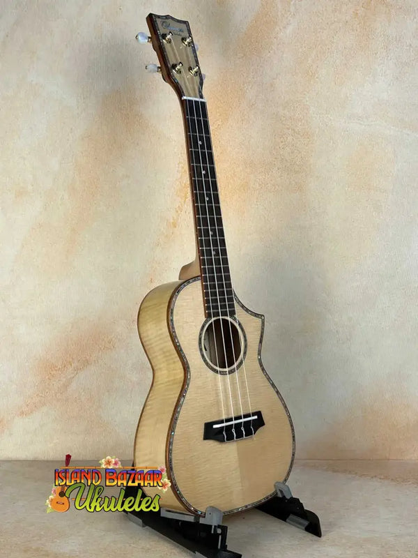 Light-colored wooden Ohana CK-75CG Concert Ukulele on a black stand, limited edition