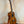 Wooden Ohana TK-350G Tenor Ukulele on a sleek black stand showcasing its elegant finish