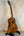 Wooden Ohana TK-350G Tenor Ukulele on a sleek black stand showcasing its elegant finish
