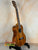 Wooden Ohana TK-350G Tenor Ukulele on a sleek black stand showcasing its elegant finish