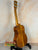 Wooden acoustic guitar on a black stand showcasing Ohana TK-350G Tenor Ukulele