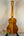 Ohana TK-350G Tenor Ukulele in honey finish on a black stand showcasing premium quality
