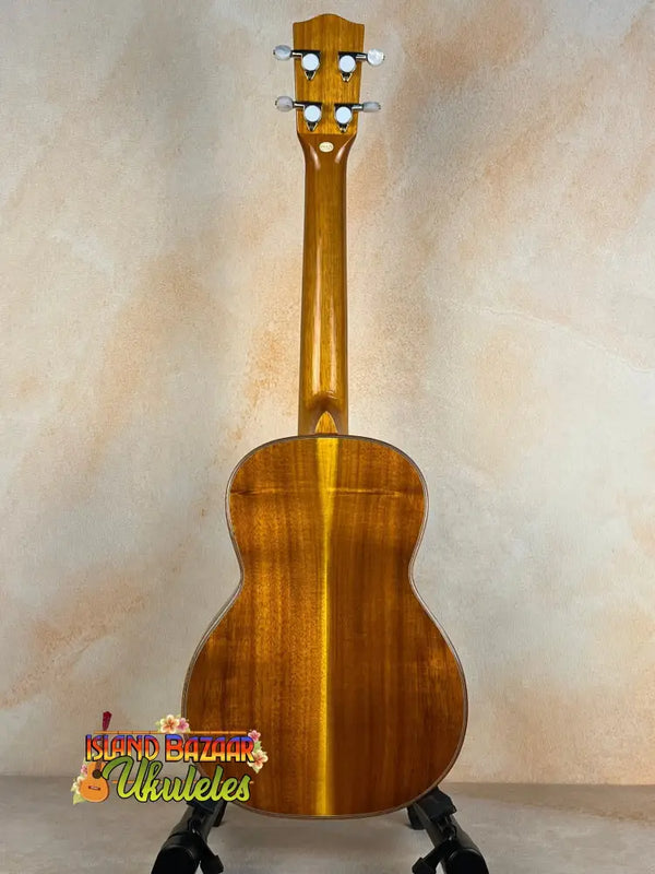 Ohana TK-350G Tenor Ukulele in honey finish on a black stand showcasing premium quality