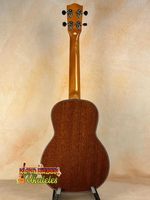 Wooden acoustic guitar with natural finish on display, Ohana TK-35G Solid Mahogany Tenor