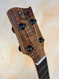 Wooden headstock of Phil Henderson Tenor Ukulele featuring tuning pegs and sound port.