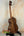 Wooden ukulele with rich brown grain on stand from Phil Henderson Ukuleles Chocolate Thunder Solid Koa Tenor