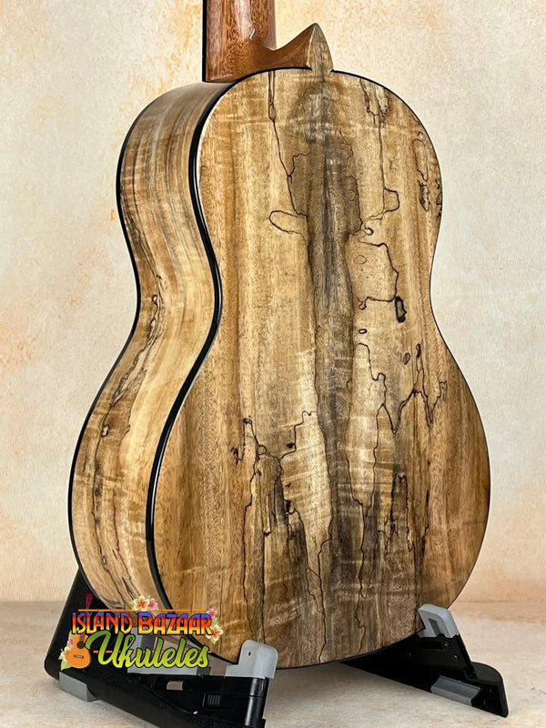 Wooden acoustic guitar with spalted maple back displayed with Romero RC-R-MG Tenor Ukulele