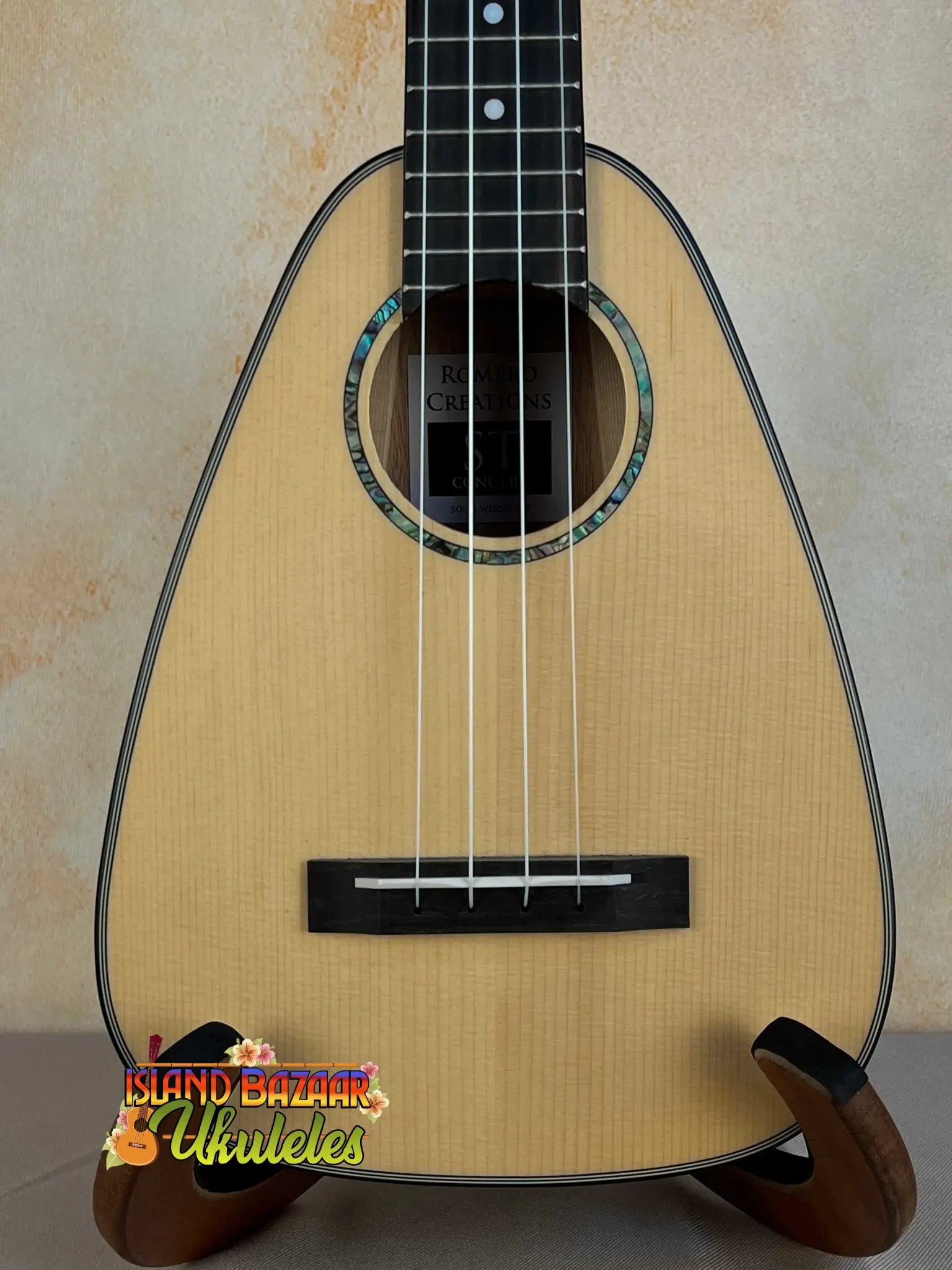 Triangle-shaped natural wood ukulele from Romero Creations with polyfoam case