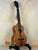 Wooden KoAloha Royal Pikake Tenor Ukulele resting elegantly on a black stand
